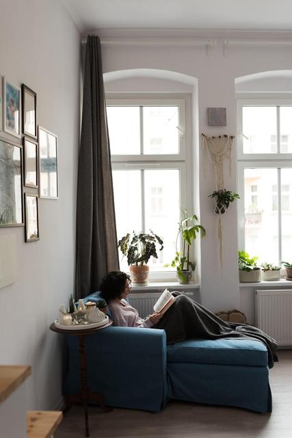 Beautiful woman relaxing on sofa and reading book at home