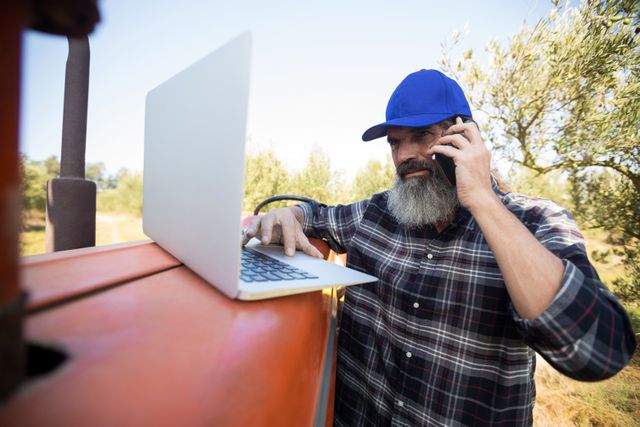 Man using laptop while talking on mobile phone - Download Free Stock Photos Pikwizard.com