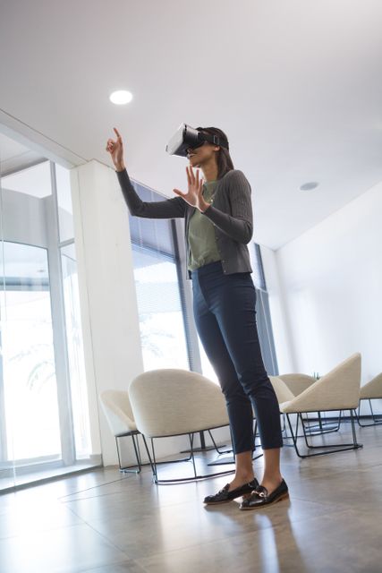 Female executive using virtual reality headset in waiting area