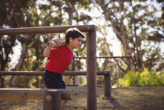 Happy boy exercising with log while listening music during obstacle course - Download Free Stock Photos Pikwizard.com