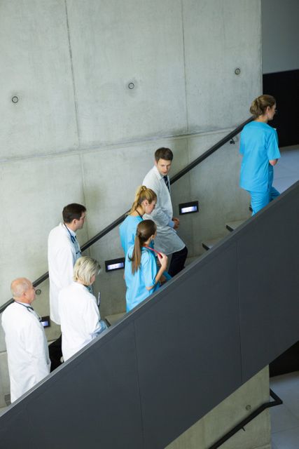 Group of doctors and surgeons interacting with each other on staircase - Download Free Stock Photos Pikwizard.com