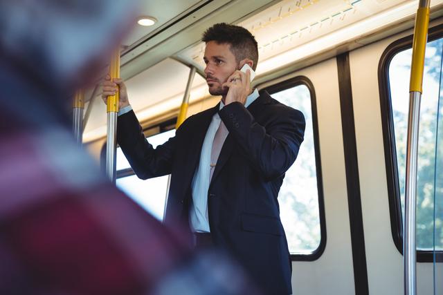 Businessman talking on mobile phone while travelling - Download Free Stock Photos Pikwizard.com
