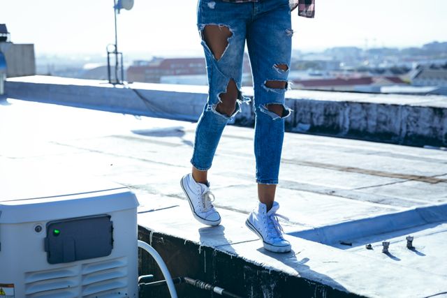 Young mixed race woman standing on an urban rooftop - Download Free Stock Photos Pikwizard.com