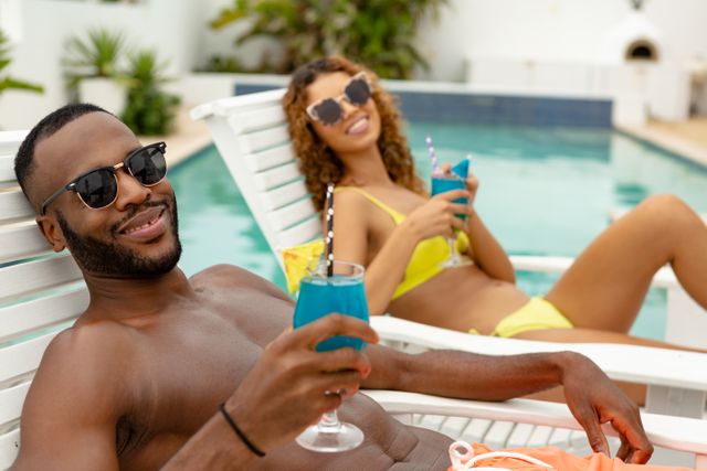 Couple having cocktail drink while relaxing on a sun lounger - Download Free Stock Photos Pikwizard.com