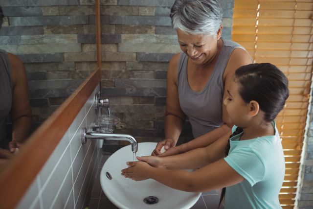 Grandmother and granddaughter washing hands in bathroom sink - Download Free Stock Photos Pikwizard.com