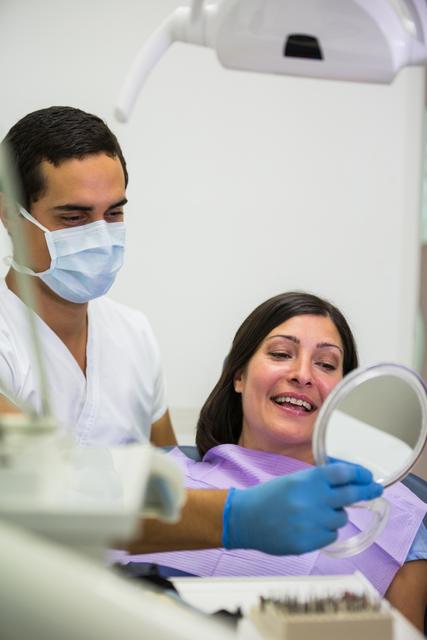 Dentist holding mirror in front of patient - Download Free Stock Photos Pikwizard.com