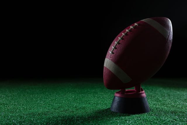Close-up of American football standing on holder on artificial turf - Download Free Stock Photos Pikwizard.com