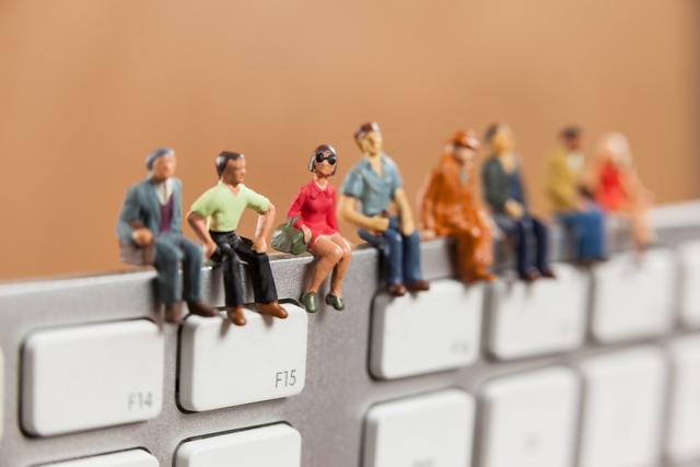 Miniature people sitting on top of keyboard - Download Free Stock Photos Pikwizard.com