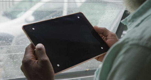 Image of african american senior man using tablet with black screen. retirement lifestyle, spending time alone at home concept digitally generated image.