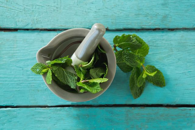Mint leaves with mortar and pestle on wooden table - Download Free Stock Photos Pikwizard.com