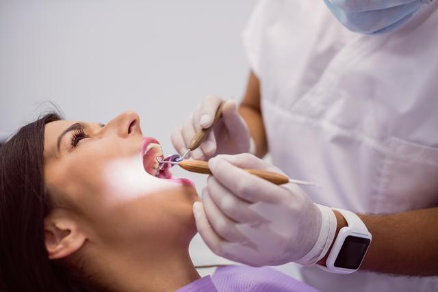 Dentist examining female patient teeth in clinic