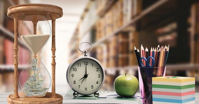 Hour glass, alarm clock, apple and pen holder against library in background - Download Free Stock Photos Pikwizard.com