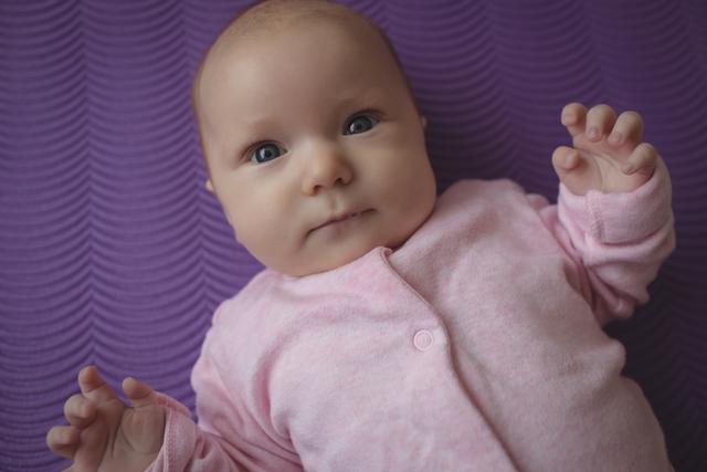 Portrait of cute baby lying on yoga mat at home