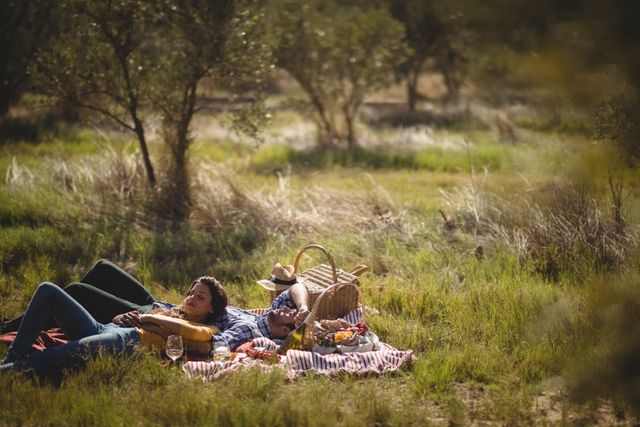 Young couple resting together on picnic blanket at olive farm - Download Free Stock Photos Pikwizard.com