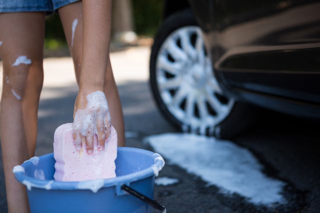 Teenage girl washing a car on a sunny day - Download Free Stock Photos Pikwizard.com