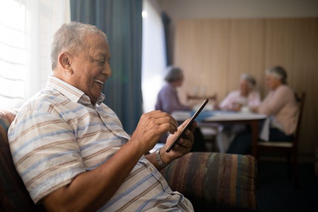 Happy senior man using phone while sitting on sofa - Download Free Stock Photos Pikwizard.com