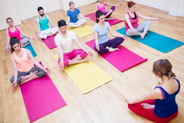 Group of people and trainer sitting in lotus position - Download Free Stock Photos Pikwizard.com