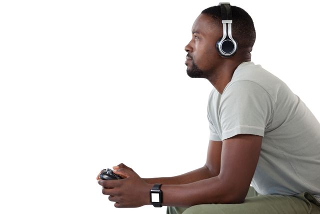 Side view of man playing video game against white background