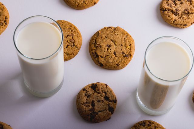 High angle view of milk glasses with cookies over white background, copy space - Download Free Stock Photos Pikwizard.com