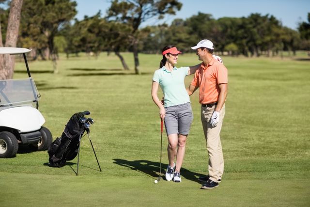 Full length of smiling golfer couple- Download Free Stock Photos Pikwizard.com