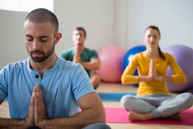 Yoga instructor with students meditating in prayer position at club  - Download Free Stock Photos Pikwizard.com