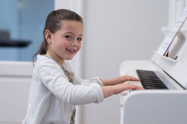 Portrait of cute girl playing piano - Download Free Stock Photos Pikwizard.com