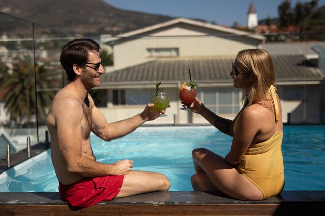 Couple enjoying cocktail by the swimming pool - Download Free Stock Photos Pikwizard.com