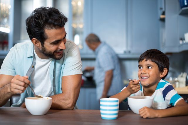 Father and son having breakfast with man in background - Download Free Stock Photos Pikwizard.com