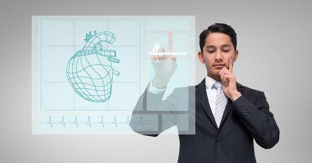 Thoughtful businessman touching human heart graphic on a digital wall - Download Free Stock Photos Pikwizard.com