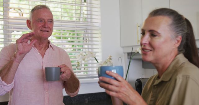 Caucasian senior couple drinking coffee together in the kitchen at home. staying at home in self isolation in quarantine lockdown