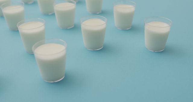 Image of row of glasses of milk on blue background - Download Free Stock Photos Pikwizard.com