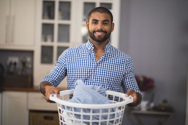 Portrait of smiling man holding laundry basket - Download Free Stock Photos Pikwizard.com