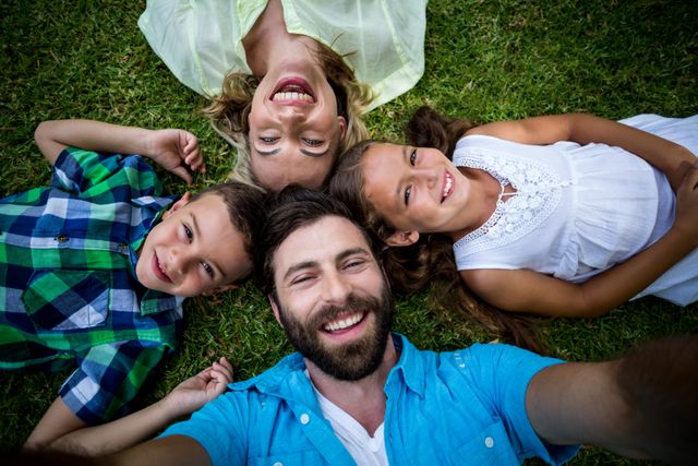 Cheerful family lying on grass in yard  - Download Free Stock Photos Pikwizard.com