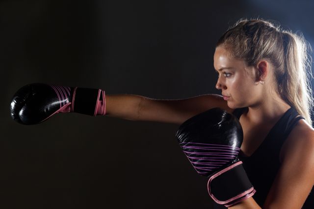 Determined woman practicing boxing in fitness studio