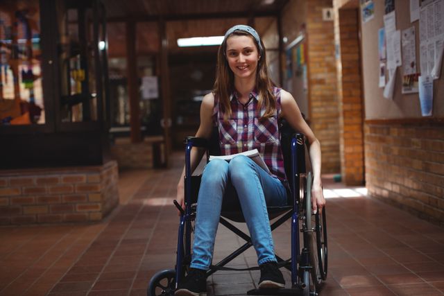 Disabled schoolgirl on wheelchair in corridor at school - Download Free Stock Photos Pikwizard.com