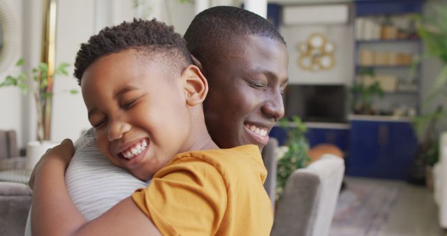Image of happy african american father and son hugging at home - Download Free Stock Photos Pikwizard.com