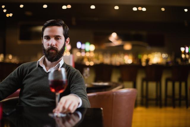 Man looking at glass of red wine - Download Free Stock Photos Pikwizard.com