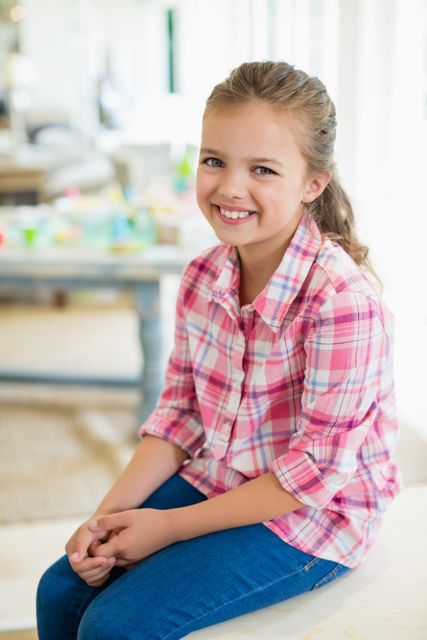 Smiling cute girl sitting on table - Download Free Stock Photos Pikwizard.com