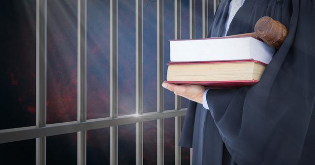 Judge holding books in front of prison cell bars - Download Free Stock Photos Pikwizard.com