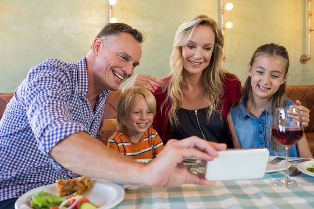 Father taking selfie with family at restaurant - Download Free Stock Photos Pikwizard.com