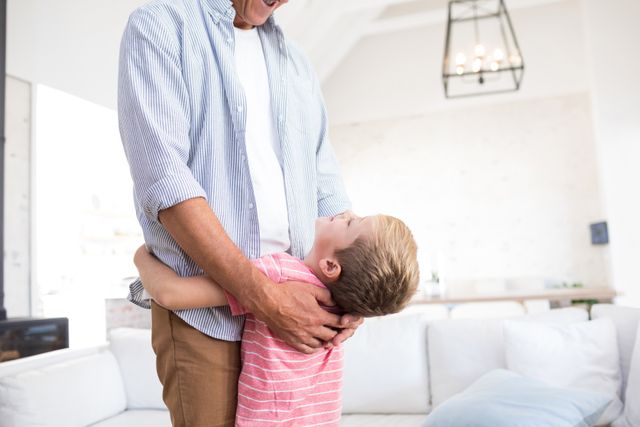 Happy father and son embracing each other in living room - Download Free Stock Photos Pikwizard.com