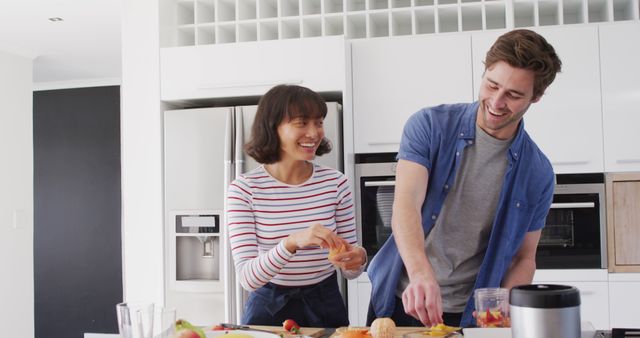 Image of diverse couple preparing fruits for juice. Love, relationship and spending quality time together concept.