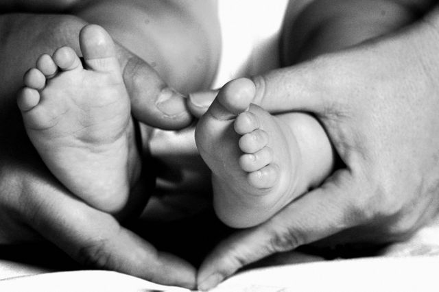 a baby's feet being held by two hands - Download Free Stock Photos Pikwizard.com