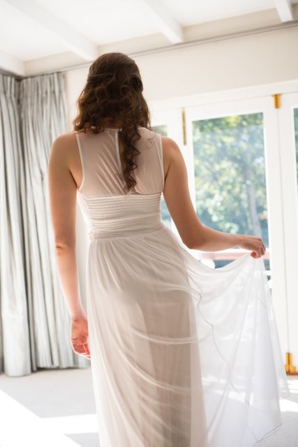 Young bride in wedding dress standing at home - Download Free Stock Photos Pikwizard.com