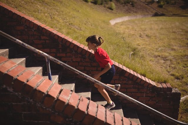 Determined girl running upstairs during obstacle course - Download Free Stock Photos Pikwizard.com