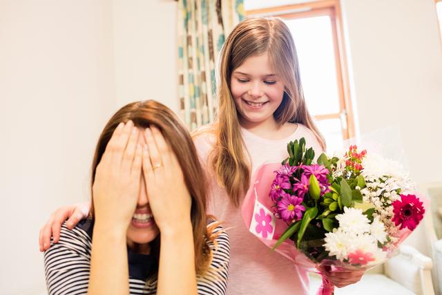 Mother covering her eyes while receiving gift from daughter - Download Free Stock Photos Pikwizard.com