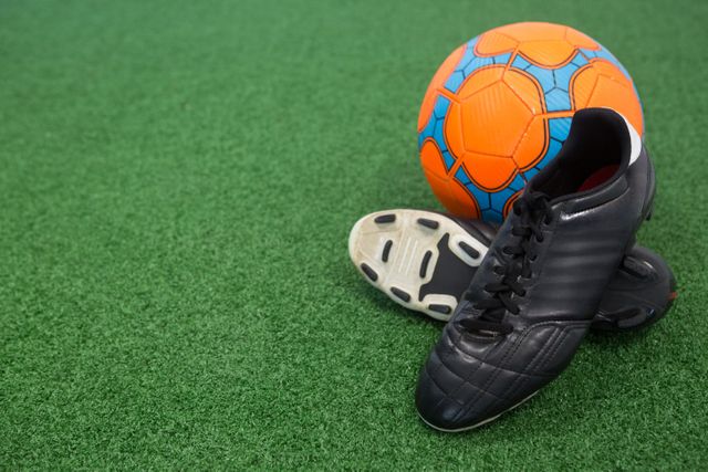 Football and cleats on artificial grass - Download Free Stock Photos Pikwizard.com