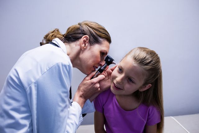 Female doctor examining patient ear with otoscope - Download Free Stock Photos Pikwizard.com