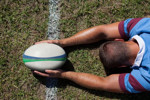 Rear view of rugby player holding ball on goal line - Download Free Stock Photos Pikwizard.com