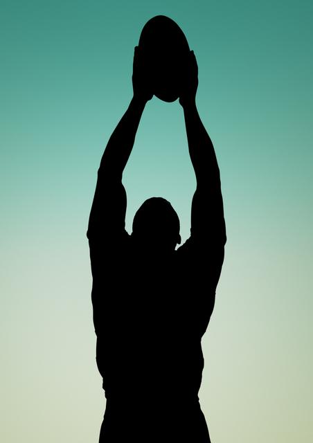 Silhouette of player catching a rugby ball against green background